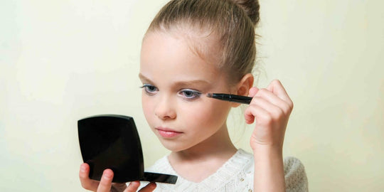 Young Girl Applying Makeup while Holding Compact Mirror
