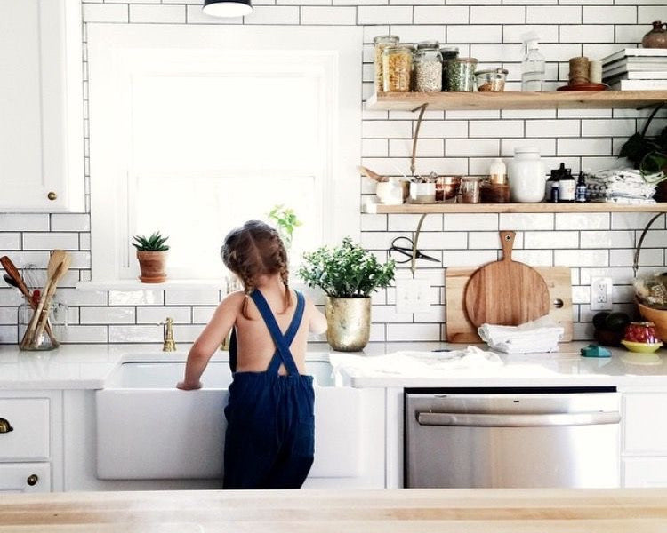 Little girl cleaning kitchen sink