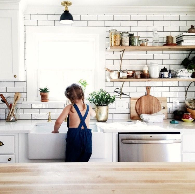 Little girl cleaning kitchen sink